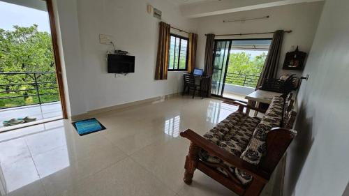a living room with a couch and a television at Nakshatra in Sawantwadi
