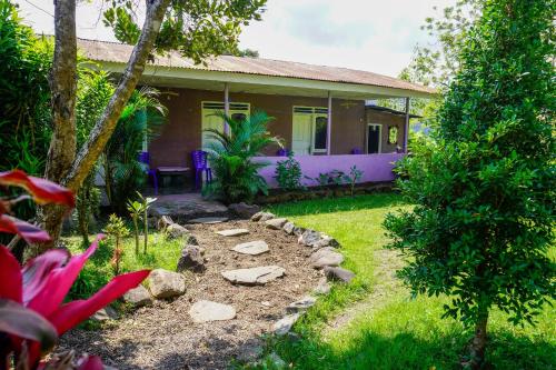 a house with a garden in front of it at Legend Guesthouse in Kelimutu