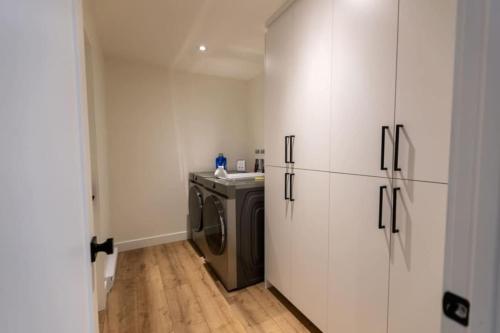 a kitchen with a washer and dryer in a room at Perchë Private SPA and Sauna Pool Table BBQ in Brownsburg