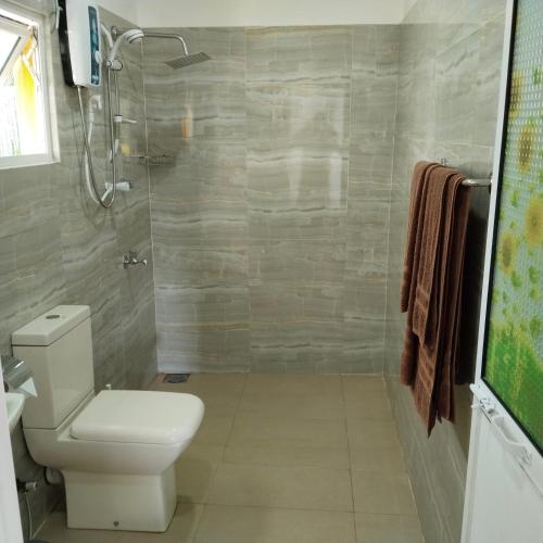 a bathroom with a toilet and a shower at Tharul Home in Bentota