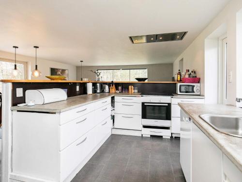 a kitchen with white cabinets and a sink at 6 person holiday home in Blokhus in Blokhus