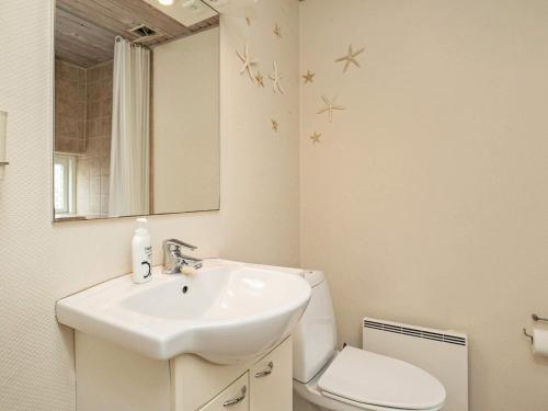 a bathroom with a sink and a toilet and a mirror at 4 person holiday home in Ærøskøbing-By Traum in Ærøskøbing