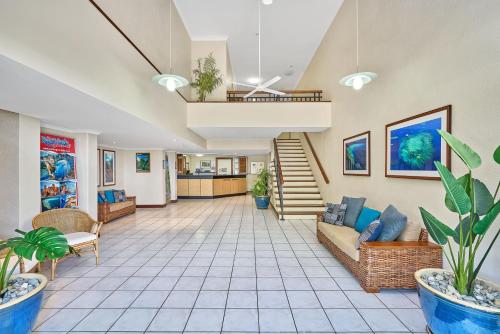 a living room with a couch and a staircase at Trinity Beach Club Holiday Apartments in Trinity Beach