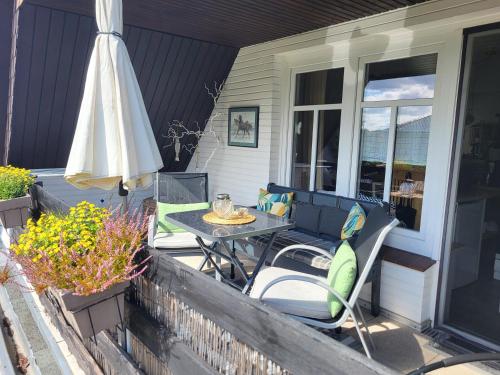 a patio with an umbrella and a table and chairs at Ferien zwischen den Meeren in Jübek