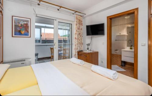 a bedroom with a large bed and a television at Villa Ana Apartman s kuhinjom i pogledom na more in Selce