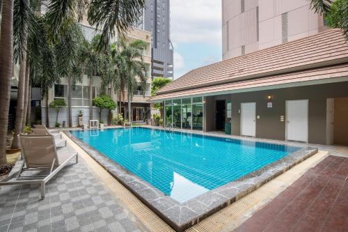 a swimming pool in the middle of a building at Diya Hotel Bangkok in Amphoe Phra Khanong