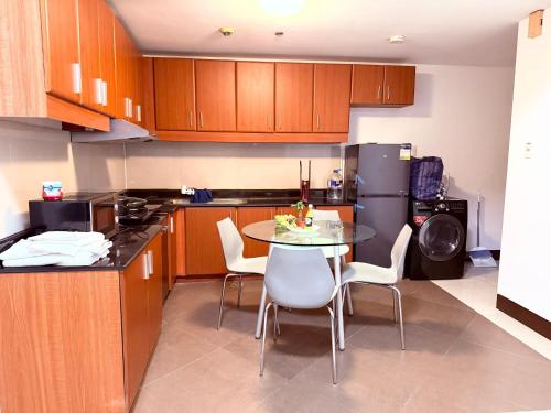 a kitchen with a table and chairs and a refrigerator at Executive Suites Bellagio Golf View Residences in Manila