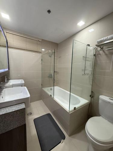 a bathroom with a toilet and a shower and a sink at Executive Suites 4 Bedroom Condo Uptown Parksuites Bgc in Manila