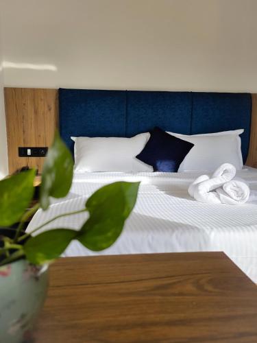 a bedroom with a white bed with a blue headboard at Ross Harriet View in Port Blair