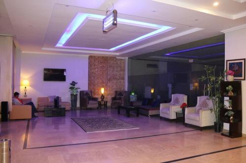 a lobby with couches and chairs in a building at Hotel Airport View in Lahore
