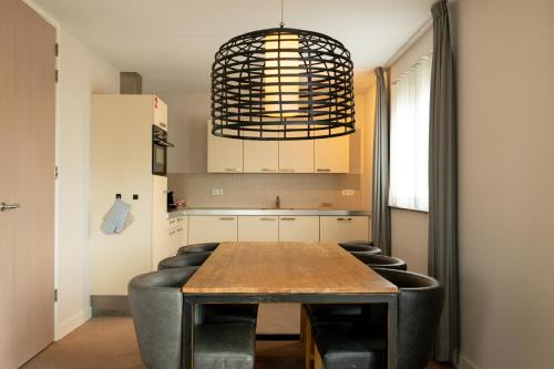 a kitchen with a wooden table and black leather chairs at Vlierijck in Oost-Vlieland
