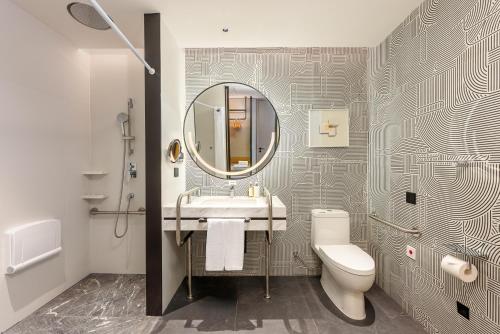 a bathroom with a sink and a toilet and a mirror at Holiday Inn Fuzhou Exhibition Center in Fuzhou