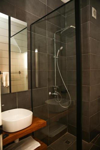 a bathroom with a glass shower with a sink at Innoplaza Cocody in Abidjan