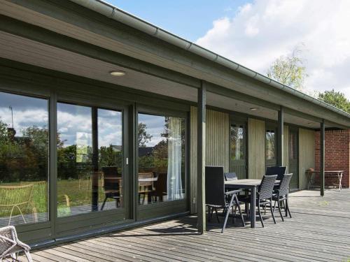 a patio with a table and chairs on a deck at 6 person holiday home in Ebeltoft-By Traum in Ebeltoft