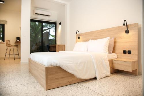 a bedroom with a large bed with a wooden headboard at Innoplaza Cocody in Abidjan