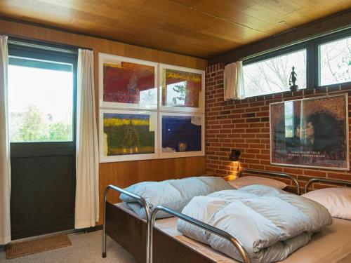 a bedroom with a bed in a room with windows at 6 person holiday home in Ebeltoft-By Traum in Ebeltoft