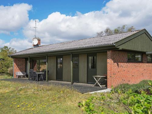 a red brick house with a clock on the roof at 6 person holiday home in Ebeltoft-By Traum in Ebeltoft