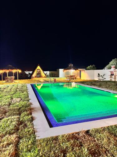 a swimming pool in a yard at night at Maison dar jad in Chaba Remada