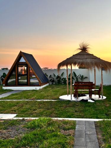 a cabin with a bench and an umbrella at Maison dar jad in Chaba Remada