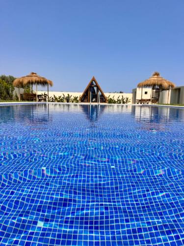 a swimming pool with blue tiles on top of it at Maison dar jad in Chaba Remada