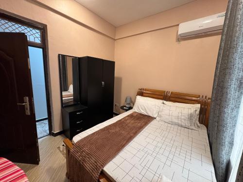 a bedroom with a bed and a window at Sinza Hiddenout in Dar es Salaam