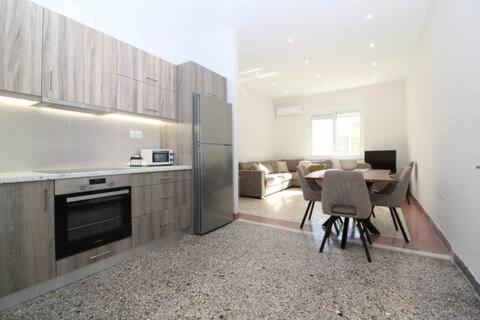 a kitchen and living room with a table and a refrigerator at Katie's House in Sparti