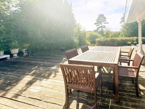 a wooden table and chairs on a patio at 6 person holiday home in Dronningmølle-By Traum in Hornbæk