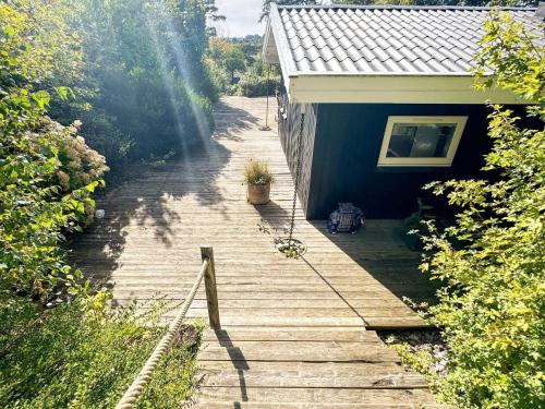 a wooden walkway next to a blue house at 6 person holiday home in Dronningmølle-By Traum in Hornbæk