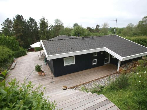 a black tiny house on a wooden deck at 6 person holiday home in Dronningmølle-By Traum in Hornbæk
