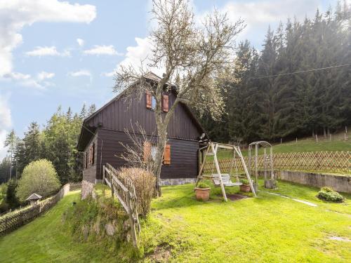 a house with a playground in a yard at Chalet in Kalchberg near Klippitztörl Ski in Bad Sankt Leonhard im Lavanttal