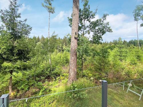 un albero con una casetta per uccelli accanto a una recinzione di 5 person holiday home in TENHULT JÖNKÖPING a Hult