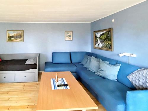 a living room with a blue couch and a table at 5 person holiday home in Tenhult Jönköping in Hult