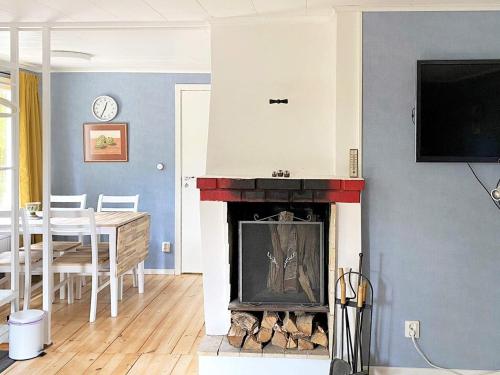 a living room with a fireplace and a dining room at 5 person holiday home in Tenhult Jönköping in Hult