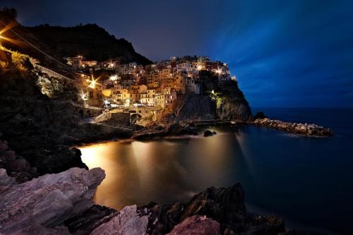 a town on the side of a mountain at night at Cinque Terre Bridge in La Spezia