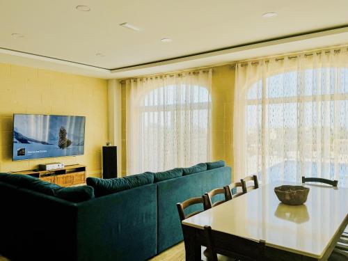 Una sala de estar con un sofá azul y una mesa. en Danny house, en Nadur