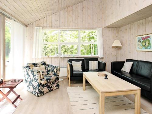 a living room with a couch and a table at 4 star holiday home in Ålbæk in Bunken