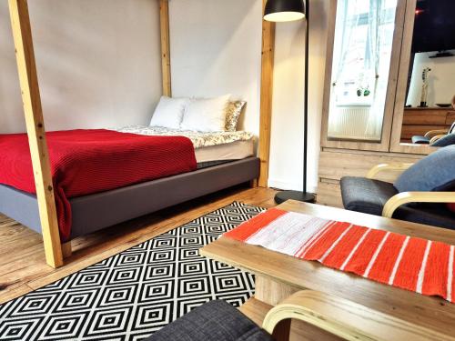 a bedroom with a bed with a red blanket at Apartamenty Stary Rzeszów in Rzeszów