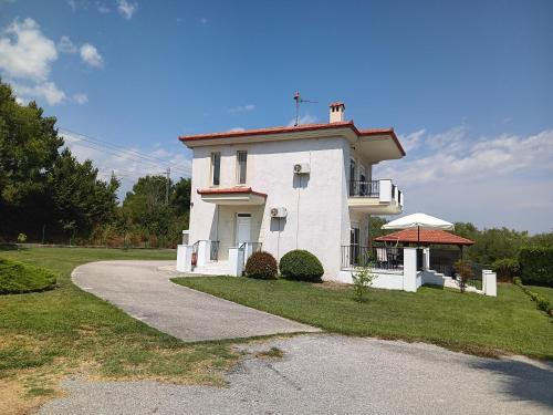 a white house with a porch and a driveway at OASIS VILLA in Litochoro