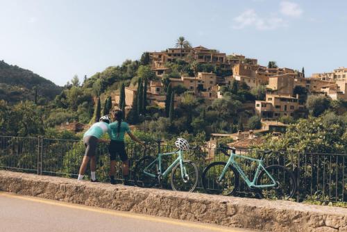 two people standing next to their bikes on a fence at La Residencia, A Belmond Hotel, Mallorca in Deia