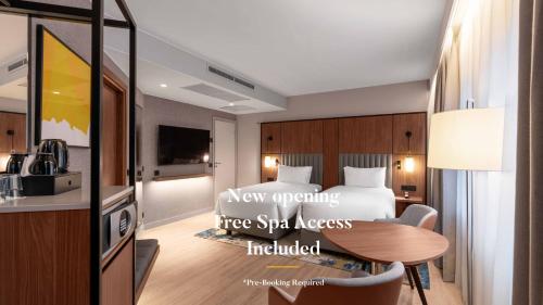 a bedroom with a bed and a table in a room at voco Stockholm - Kista by IHG in Stockholm