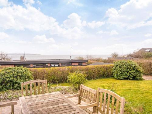two wooden benches in a yard with a building in the background at 6 person holiday home in Børkop-By Traum in Børkop