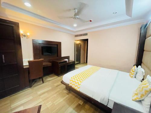 a bedroom with a bed and a desk and a television at Hotel Imperial Inn - Nehru Place in New Delhi