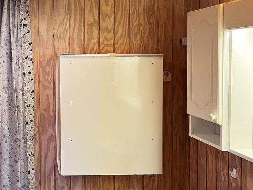 a refrigerator on a wooden wall next to a cabinet at 8 person holiday home in Svendborg-By Traum in Svendborg