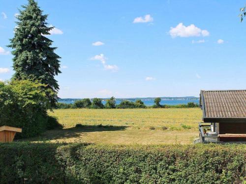 a view of a field with a tree and a house at 8 person holiday home in Svendborg-By Traum in Svendborg