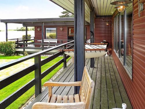 a porch with a bench and a boat on it at 8 person holiday home in Svendborg-By Traum in Svendborg