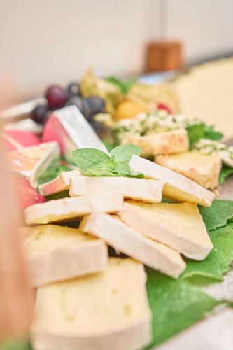 a plate of food with cheese and fruit on it at Hotel Lindenhof in Kellberg
