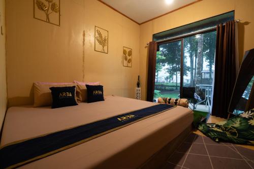 a bedroom with a large bed and a large window at Kuleum Camp And Cabin By ARBA in Baruhtunggul