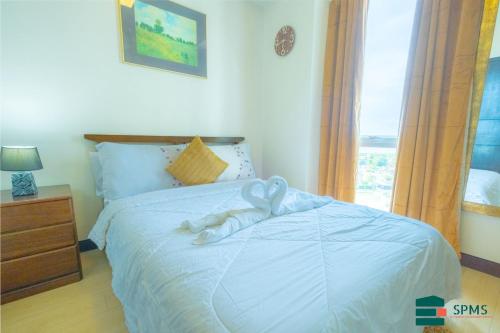 a white stuffed animal on a bed in a bedroom at Mactan Newtown Cebu Affordable Suite! in Mactan