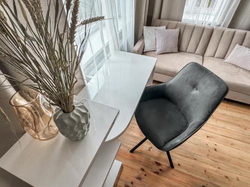 a living room with a white table and a chair at Pie Jūras in Saulkrasti