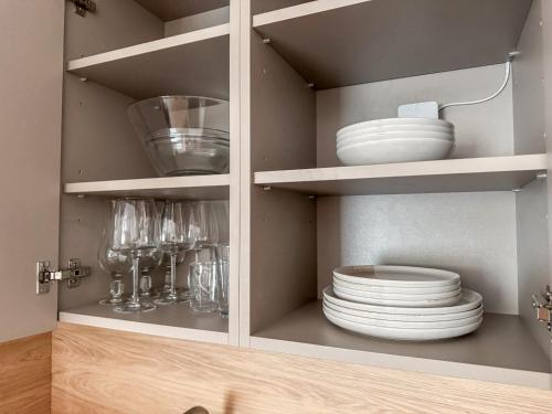 a cupboard with plates and dishes in it at Pie Jūras in Saulkrasti